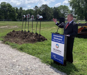 Mike Sanders, Executive Director, Oklahoma's Broadband Office talking at lectern during a fiber broadband ground breaking ceremony.